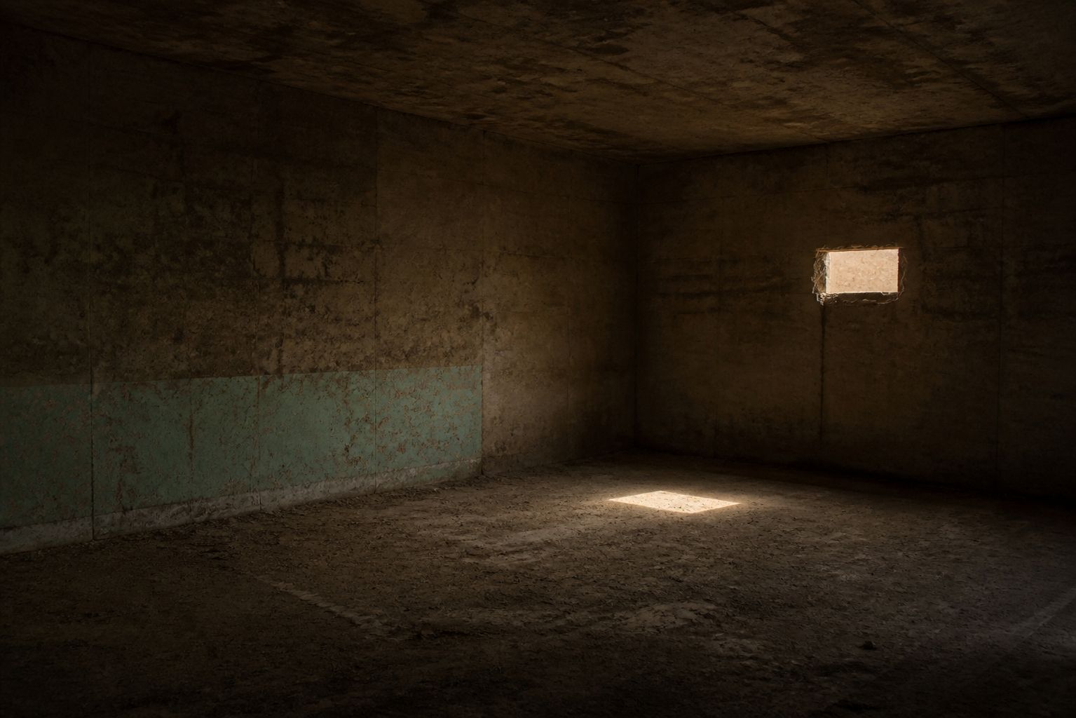 Interior de concreto con una sola entrada de luz